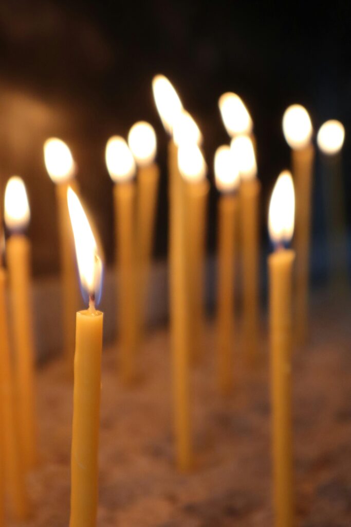 pexels-photo-16900573-16900573 A serene arrangement of lit candles creating a warm ambiance indoors.